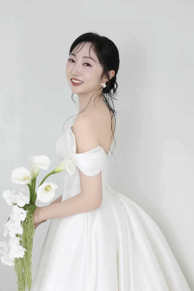 흰 꽃다발을 든 신부의 단독 사진